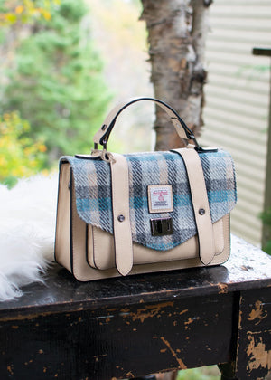 Handbag with plaid pattern on a wooden table outdoors